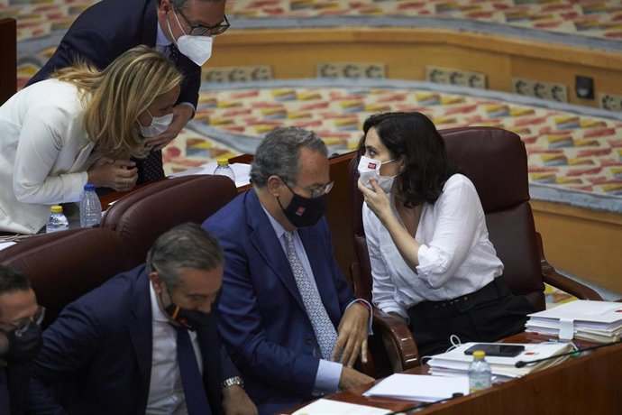 La presidenta en funciones de la Comunidad de Madrid, Isabel Díaz Ayuso, conversa con la consejera de Medio Ambiente, Ordenación del Territorio y Sostenibilidad, Paloma Martín, tras su intervención en la segunda sesión del pleno de su investidura en la 