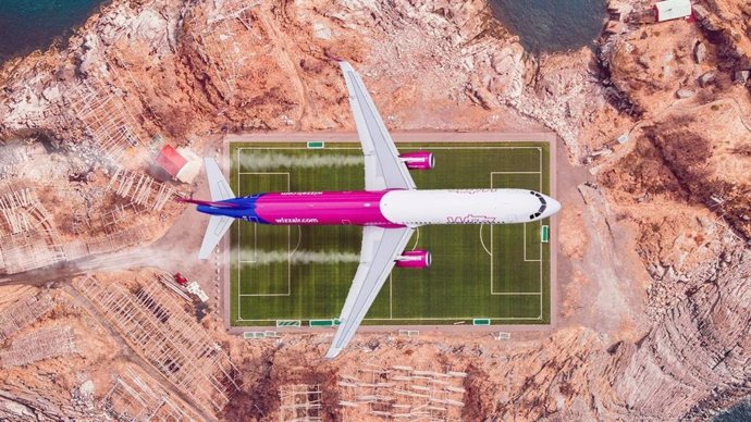 Un avión de la compañía Wizzair sobrevuela un campo de fútbol