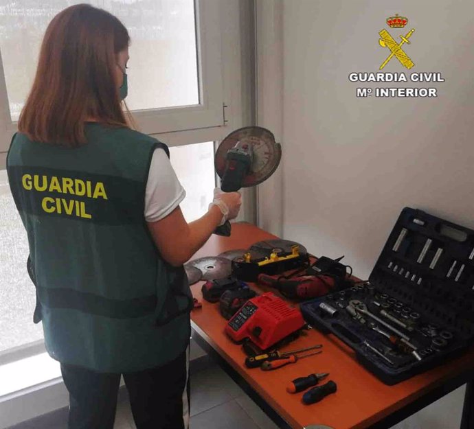 Una agente de la Guardia Civil junto a los catalizadores incautados.