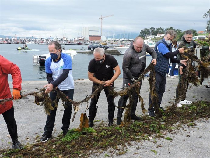 Voluntarios, entre ellos Francisco Botas y Juan Carlos Escotet, descargan los residuos en el puerto