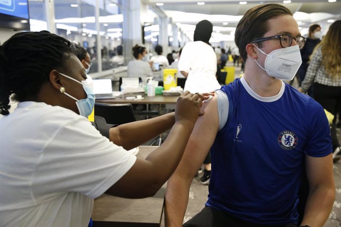 Un ciudadano con la camiseta del Chelsea FC recibe una dosis de la vacuna Pfizer en las jornadas de vacunación en estadios de fútbol londinenses