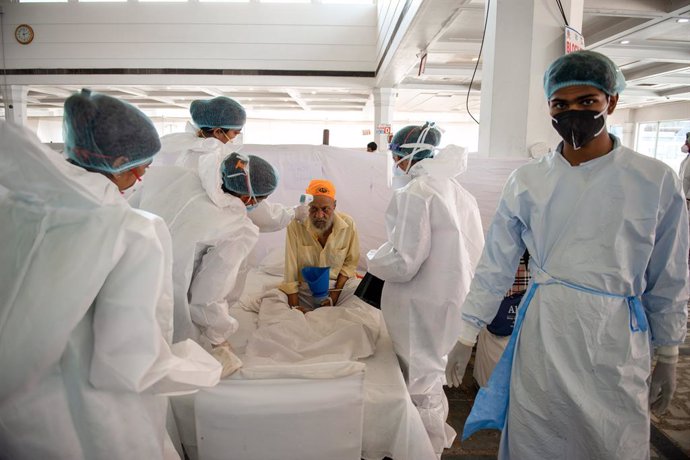 26 May 2021, India, New Delhi: Health workers take care of a diabetes patient in Sri Guru Tegh Bahadar Covid-19 Medical Isolation & Treatment Centre, at Gurdwara Rakab Ganj Sahib. Today, Thursday, the Indian Ministry of Health announced the registration