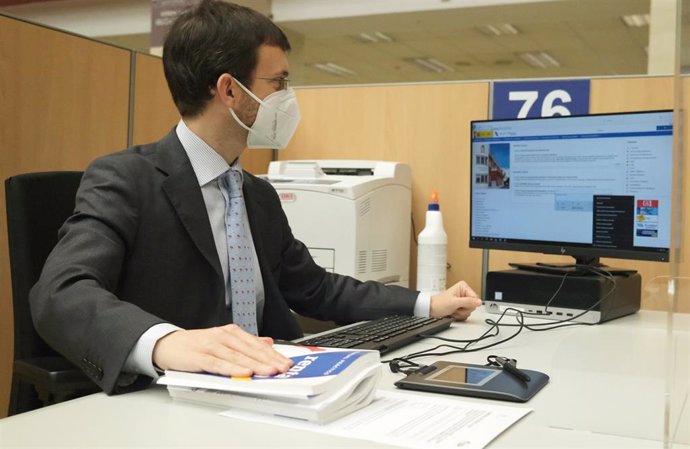 Un empleado trabaja en una oficina de la Agencia Tributaria, a 2 de junio de 2021, en Guzmán el Bueno, Madrid, (España). Las oficinas, que siguen afectadas por las medidas sanitarias de reducción de aforos y mantenimiento de distancias de seguridad en z