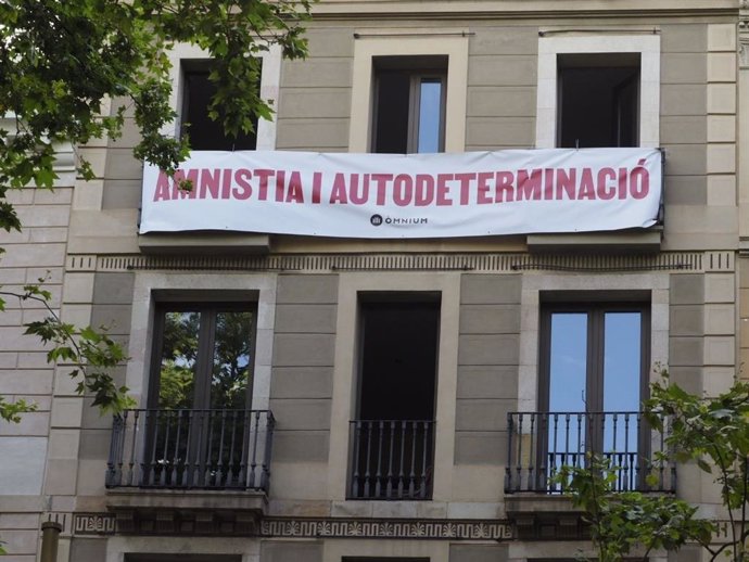mnium desplega una pancarta davant el Liceu per demanar a Sánchez amnistia i autodeterminació