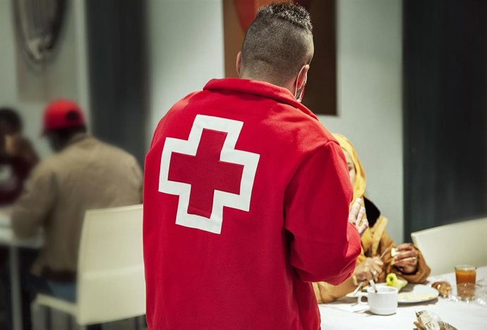 Archivo - Un voluntario de Cruz Roja atiende a refugiados.