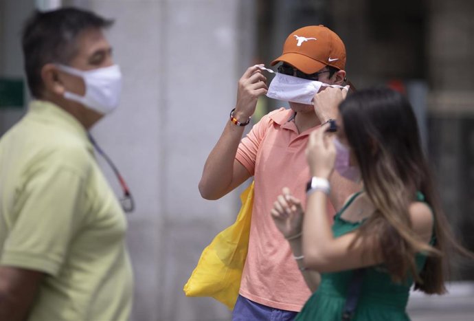Un hombre se quita la mascarilla.