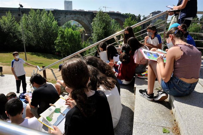 Un grupo de alumnos de un colegio dibuja cerca del Puente Romano, una de las zonas que ha amanecido sin destrozos, tras una fuerte tormenta registrada ayer en la ciudad, a 14 de junio de 2021, en Ourense, Galicia (España)