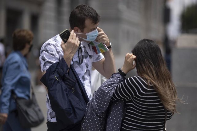 Un hombre se quita la mascarilla. 