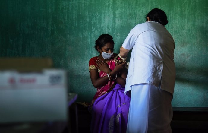 Una mujer es vacunada contra el coronavirus en India