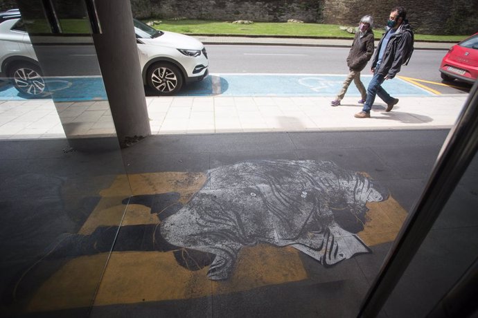 Archivo - Obra pintada en el suelo de El Primo de Banksy, colectivo con instalaciones en varias ciudades españolas, que muestra a la entrada del edificio de Sindicatos a un indigente durmiendo en la puerta de acceso, a 30 de abril de 2021, en Lugo, Gali