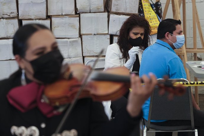Archivo - 08 May 2021, US, Los Angeles: A member of the Mariachi Serenade band plays on a violin as a man receives a coronavirus (COVID-19) vaccine at a vaccination site held by CHIRLA, the Coalition for Humane Immigrant Rights, and the Mexican Consulat