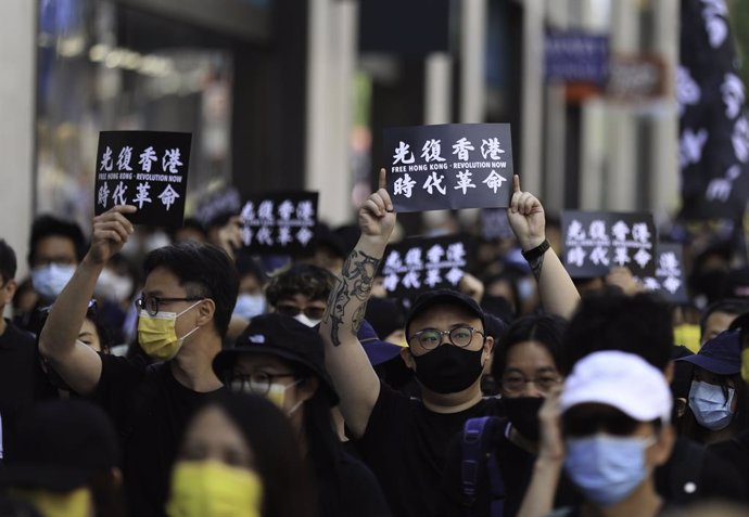 12 June 2021, United Kingdom, London: Pro-democracy activists hold placards that read "liberate Hong Kong, revolution of our times" during a rally marking the second anniversary of the start of massive pro-democracy protests which roiled Hong Kong in 20
