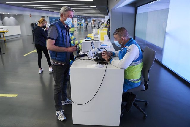 Archivo - Un hombre espera para ser registrado, después de recibir la dosis con la vacuna de Pfizer en el Wanda Metropolitano