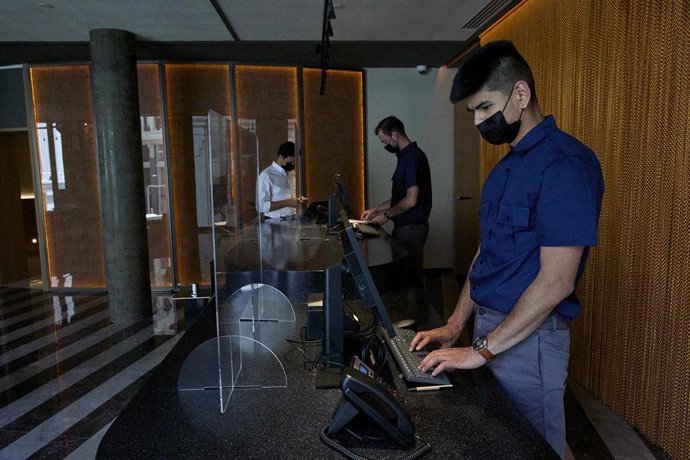 Tres hombres en la recepción de un hotel, foto de recurso