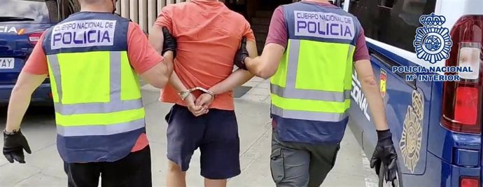 Dos agentes de la Policía Nacional acompañan a un detenido (detención, arresto)
