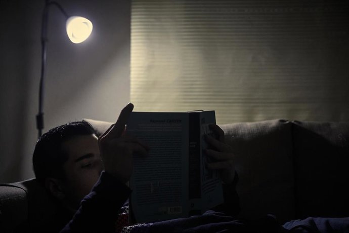 Archivo - Un chico lee un libro bajo la luz de una lámpara