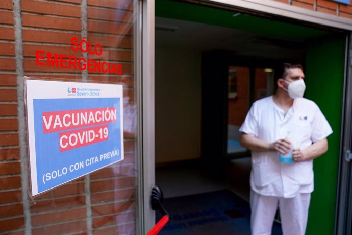 Un empleado sanitario al lado de una señal del dispositivo de vacunación puesto en marcha para inocular la primera dosis de la vacuna de Pfizer-BioNTech contra el Covid-19, a 9 de junio de 2021, en el Hospital Severo Ochoa de Leganés, Madrid, (España).