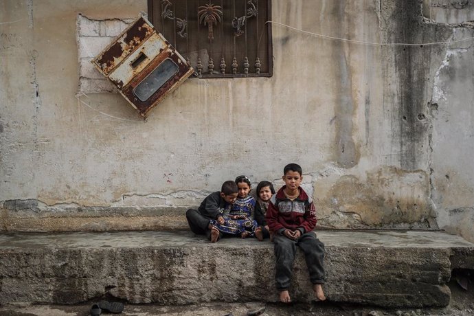 Archivo - 02 January 2021, Syria, Afes: Syrian children sit outside their home at the village of Afes. Residents of Afes started returning back to their homes after they were forced into internal displacement due to the intense bombing amid the Syrian G
