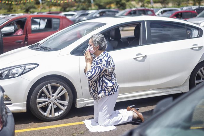 Archivo - Una mujer reza durante una eucartía celebrada en el parking del Hipódromo de los andes, en Bogotá, Colombia.