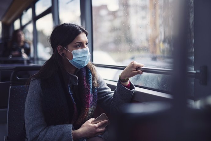 Archivo - Mujer con mascarilla en un autobús.