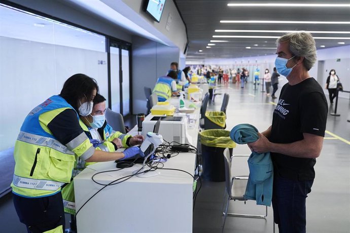 Archivo - Un hombre espera para ser registrado, después de recibir la dosis con la vacuna de Pfizer en el Wanda Metropolitano