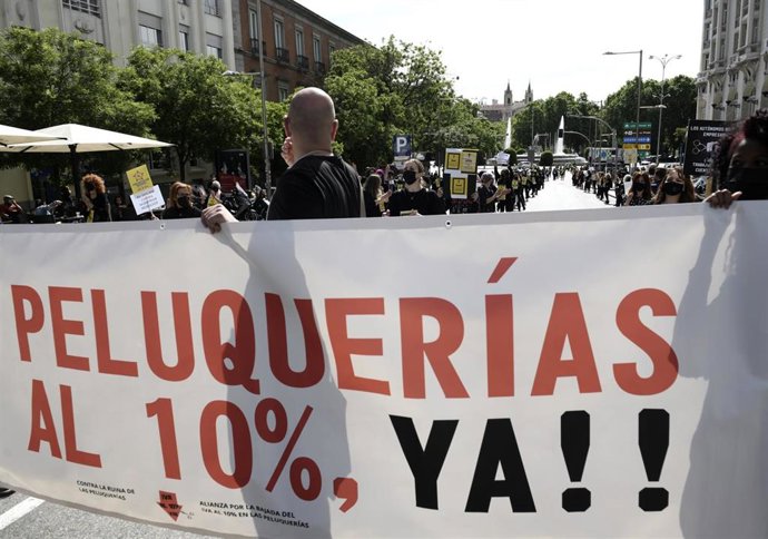 Archivo - Grupos de personas se manifiestan con una pancarta donde se puede leer "SOS PELUQUERÍAS IVA AL 10% YA!!" 