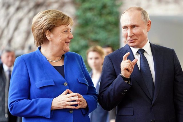 Archivo - Imagen de archivo de Merkel conversando con Putin