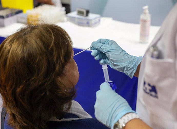 Un sanitario realiza un test de antígenos a una mujer en el intercambiador de Plaza de Castilla