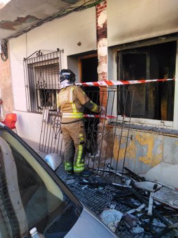 Un bombero en la puerta de la vivienda que ha sufrido el incendio