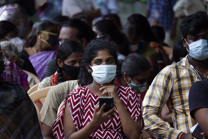Personas en India esperando a vacunarse contra el coronavirus