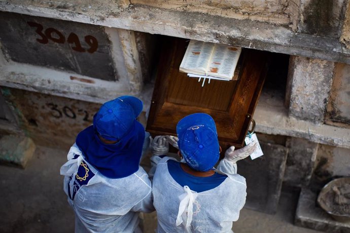 Archivo - Los trabajadores del cementerio entierran a una  víctima del coronavirus en el cementerio de Caju el 24 de marzo de 2021 en Río de Janeiro, Brasil.