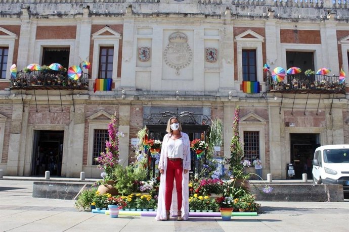 Isabel Albás en la Plaza de la Corredera decorada con macetas con los colores de las banderas trans y arcoíris.