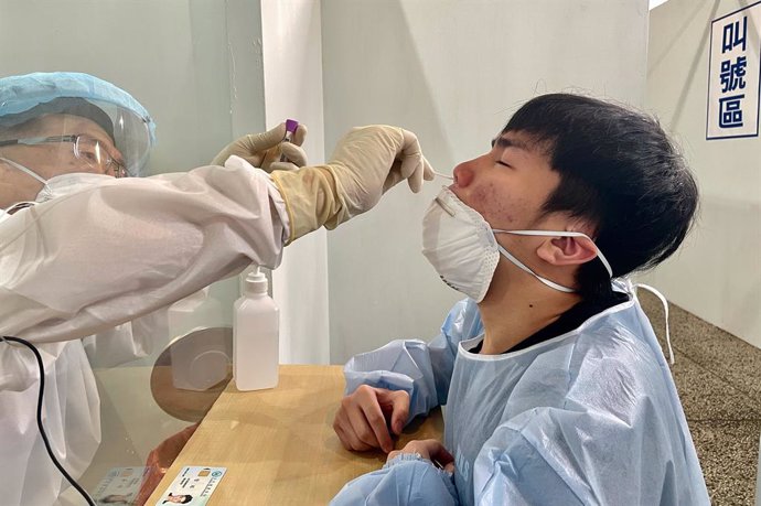25 June 2021, Taiwan, New Taipei: A health worker takes a swab from a man for the COVID-19 test at a hospital, following a jump in the number of domestic infections and deaths. Japan said Friday it will donate another one million Covid-19 vaccine doses 