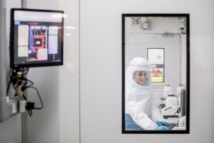 28 May 2021, South Africa, Johannesburg: A woman in a protective suit works in a high-security laboratory of the National Institute for Communicable Diseases (NICD) during a visit by German Health Minister Jens Spahn. At the request of Chancellor Merkel