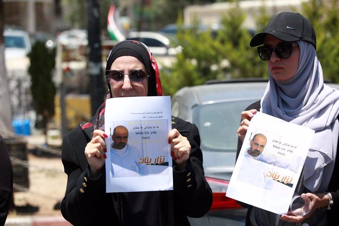 24 June 2021, Palestinian Territories, Ramallah: Demonstrators hold placards during a protest following the death of Palestinian parliamentary candidate and activist Nizar Banat, who died after being arrested by Palestinian Authority's security forces. 