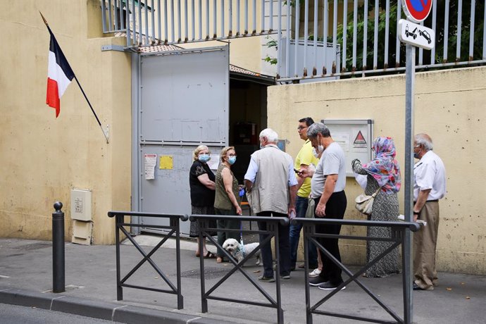 20 June 2021, France, Marseille: People stand on a Queue at the entrance of a polling station during the first round of the French regional elections. The regional elections are the last nationwide decision before the French presidential election next s