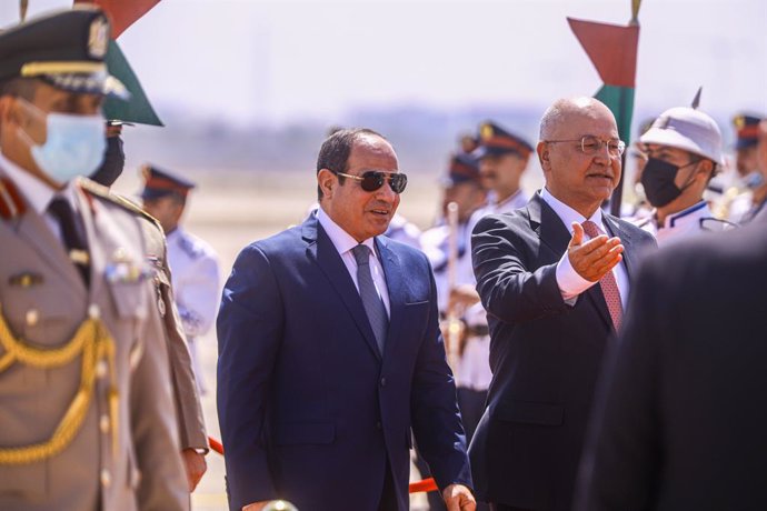27 June 2021, Iraq, Baghdad: Iraqi President Barham Salih (R) receives Egyptian President Abdel Fattah al-Sisi (C) at Baghdad International Airport ahead of the Iraqi-Egyptian-Jordanian tripartite summit. Al-Sisi is the first Egyptian President to visit