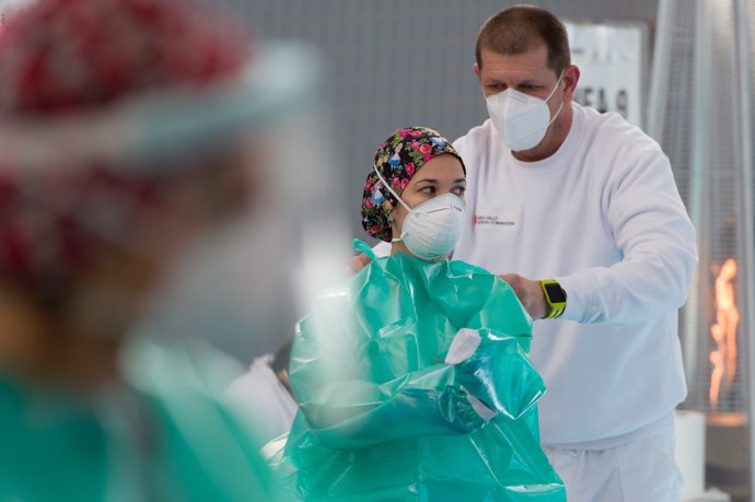 Una trabajadora sanitaria se protege para realizar tests de antígenos
