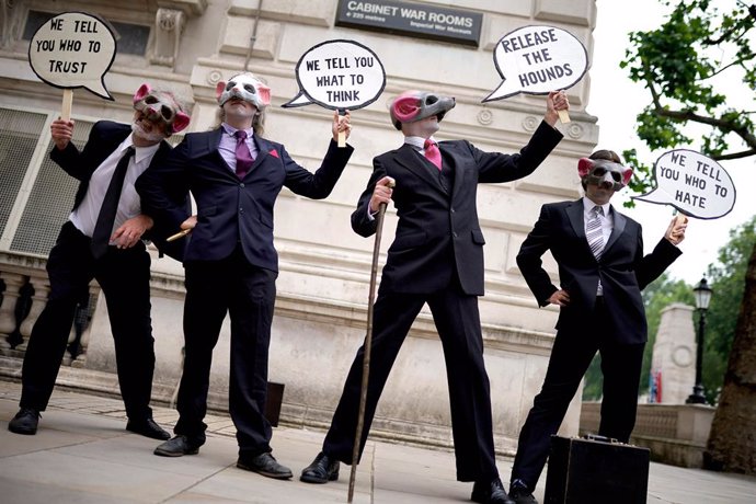 27 June 2021, United Kingdom, London: Extinction Rebellion demonstrators wearing rat masks at Whitehall take part in a protest as part of the group's "free the press" campaign. Photo: Aaron Chown/PA Wire/dpa