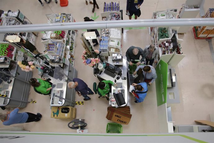 Archivo - Varias personas compran en el interior de una gran superficie