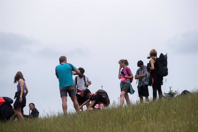 Varios peregrinos descansan sin mascarilla, en el Monte do Gozo, la última etapa del camino de Santiago, durante el primer día en el que no es obligado el uso de la mascarilla en exteriores desde el inicio de la pandemia, a 26 de junio de 2021.