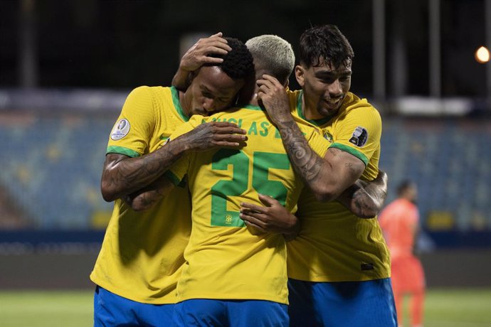 HANDOUT - 27 June 2021, Brazil, Goiania: Brazil's Eder Militao (L) celebrates scoring his side's first goal with team mates Lucas Paqueta (R) and Douglas Luiz during the CONMEBOL Copa America Group B soccer match between Brazil and Ecuador at Estadio Ol