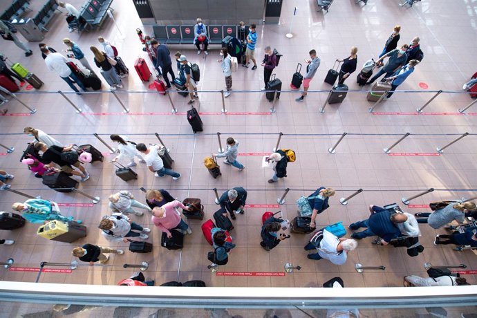 25 June 2021, Hamburg: Passengers wait in queues in front of check-in desks in Terminal 1 at Hamburg Airport. Around 100 take-offs and landings are planned for Friday, the airport announced. Around 20,000 passengers are expected to arrive or depart. Pho