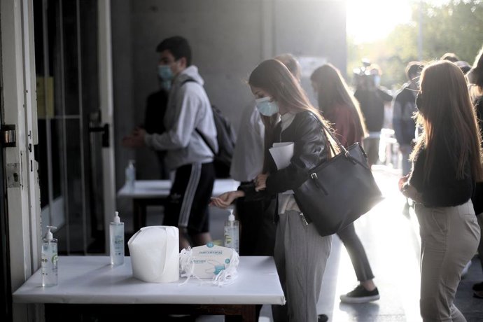 Archivo - Una alumna se desinfecta las manos antes de entrar al aula de examen de la Facultad de Derecho de la Universidad Complutense