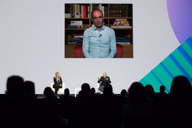 El historiador Yuval Noah Harari (en la pantalla) y el paleoantropólogo Juan Luis Arsuaga (sentado), junto a la secretaria de Estado de Digitalización e Inteligencia Artificial, Carme Artigas durante el encuentro.