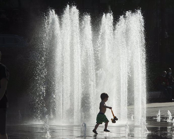 09 June 2021, Canada, Montreal: A child plays in the water of a fountain in Montreal to cool himself from the heat. Photo: Ryan Remiorz/The Canadian Press via ZUMA/dpa