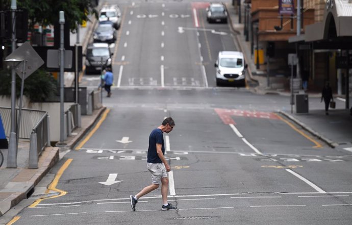 Archivo - A man is seen crossing a near empty Edward Street in the CBD of Brisbane, Tuesday, March 30, 2021. People in Greater Brisbane have been ordered into lockdown as authorities try to suppress a growing coronavirus (COVID-19) cluster of seven case