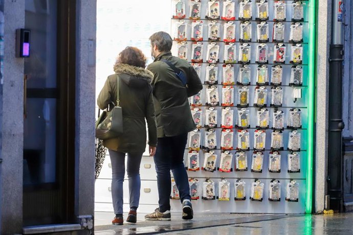 Archivo - Dos personas en la puerta de un comercio en una jornada marcada por el inicio de la entrada en vigor de una desescalada gradual en la región, en Vigo, Galicia (España), a 17 de febrero de 2021. Galicia reabre hoy cines, teatros, auditorios, bi