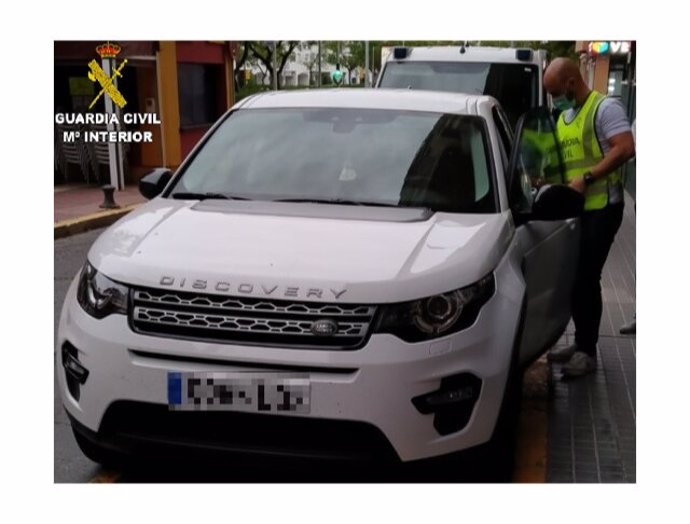 Agente de la Guardia Civil en Huelva junto al vehículo que fue objeto de estafa. 