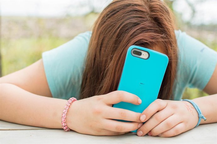 Adolescente usando un smartphone.